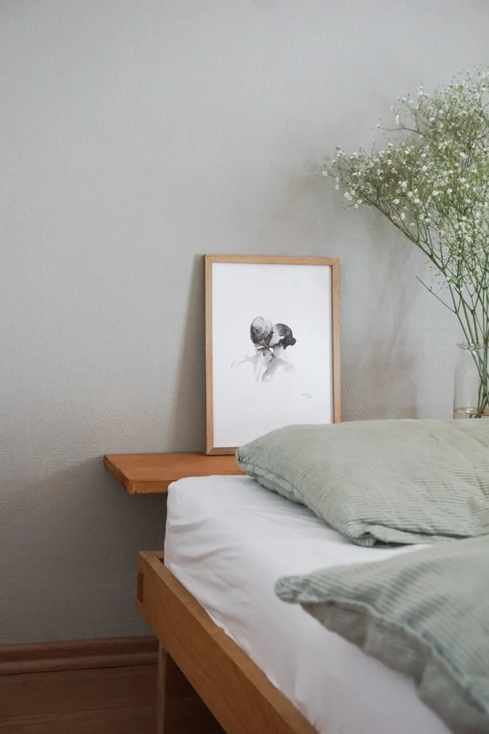 Das Paar wird nur in Grau- und Schwarztönen dargestellt. Der Kopf der Frau verschwindet hinter dem des Mannes. Auch die Oberkörper gehen optisch ineinander über.