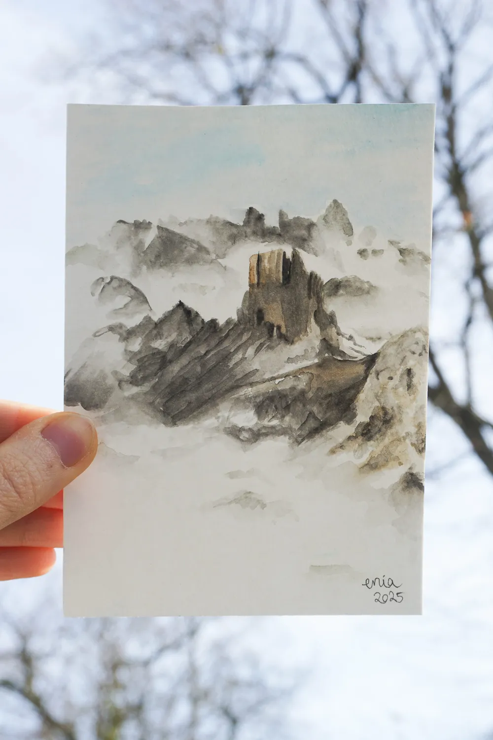 Die Wolken legen sich wie ein Schleier um die Berge. Nur die Bergspitzen ragen imposant zwischen den Wolken empor.