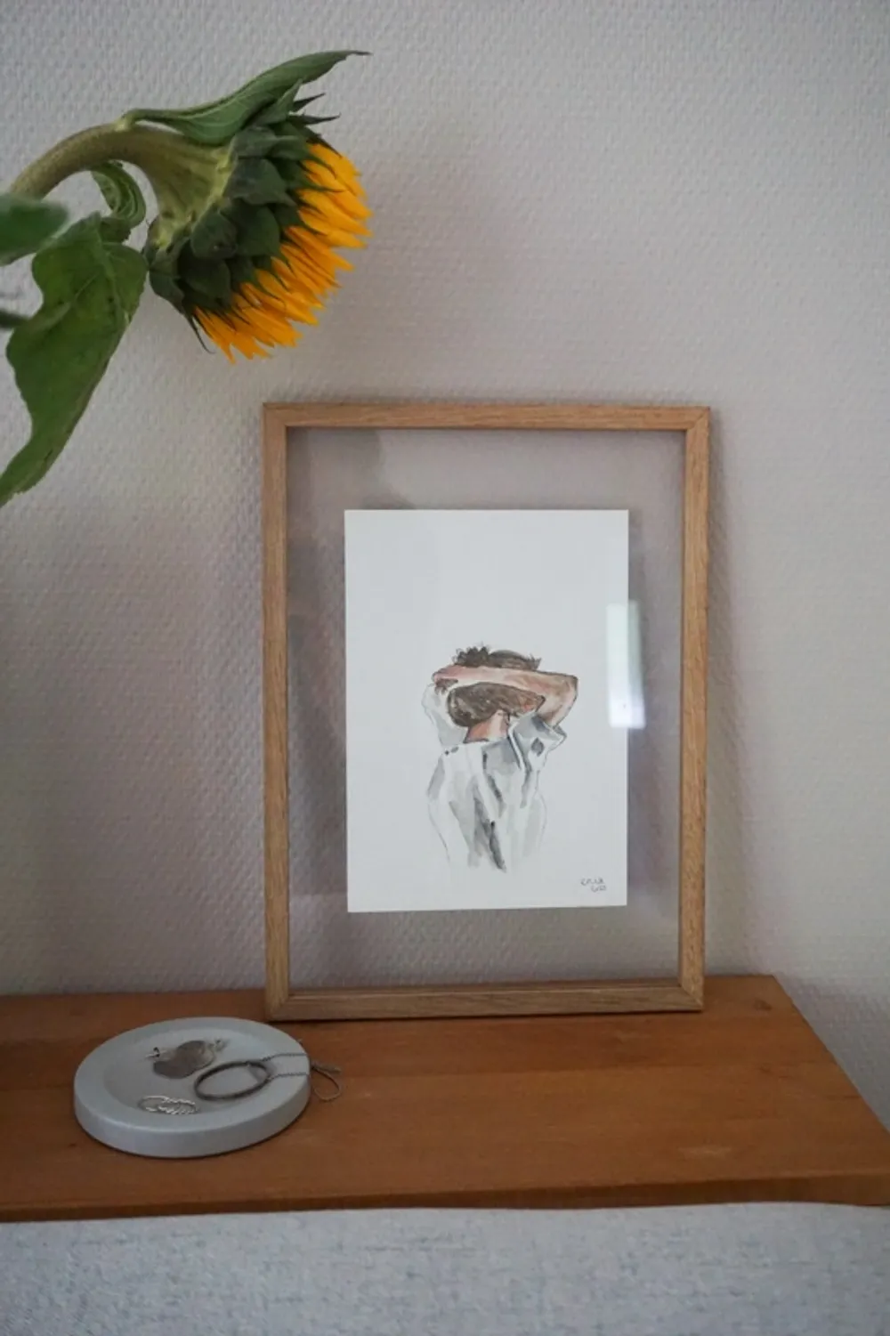 Die Frau bindet sich gerade die Haare hoch, während sie weit in die Ferne blickt.